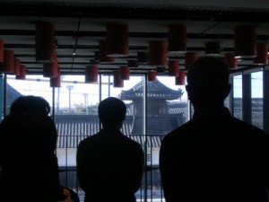 藤井達吉現代美術館の天井から吊られた作品、ガラス越しにすぐ向かいのお寺の建物が見える