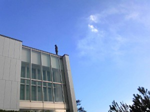 美術館屋上から山の稜線を見上げる彫像（ゴームリー作）